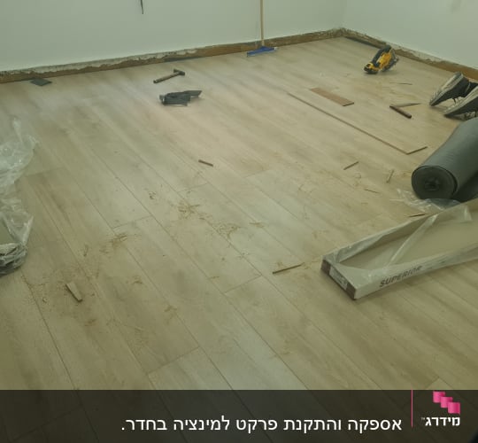 רצפת פרקט בהתקנה עם כלים וחומרים מסביב